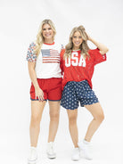 a high-stretch roomy-fit crew neck top with a sequin American flag front, lined star sleeves (red, white, and blue), red neckline trim, and a comfortable fit that runs large