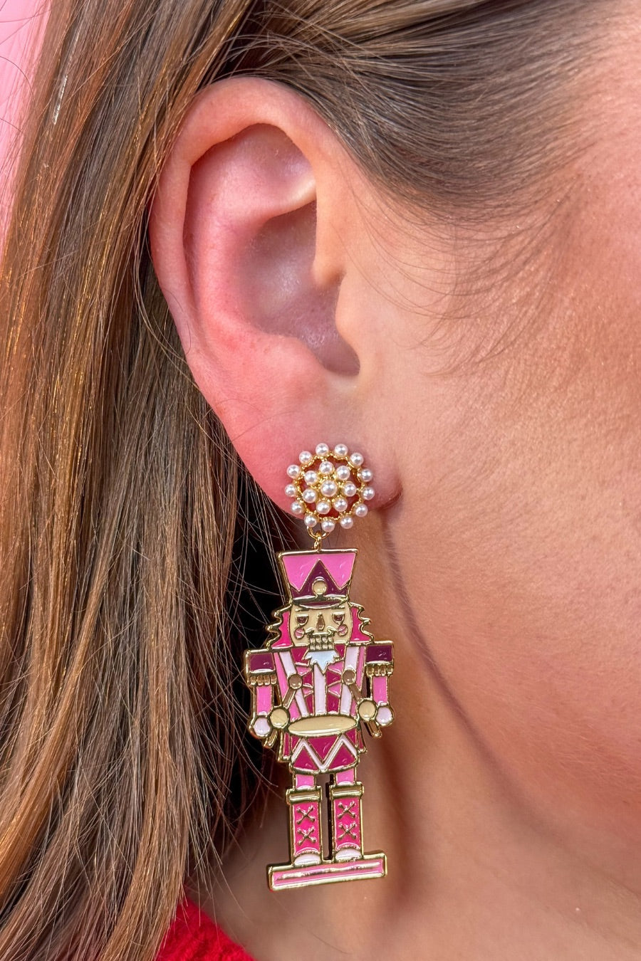 pearl cluster stud earrings paired with adorable dangling pink nutcrackers, finished in glossy gold-tone detail and gold comfort earring back