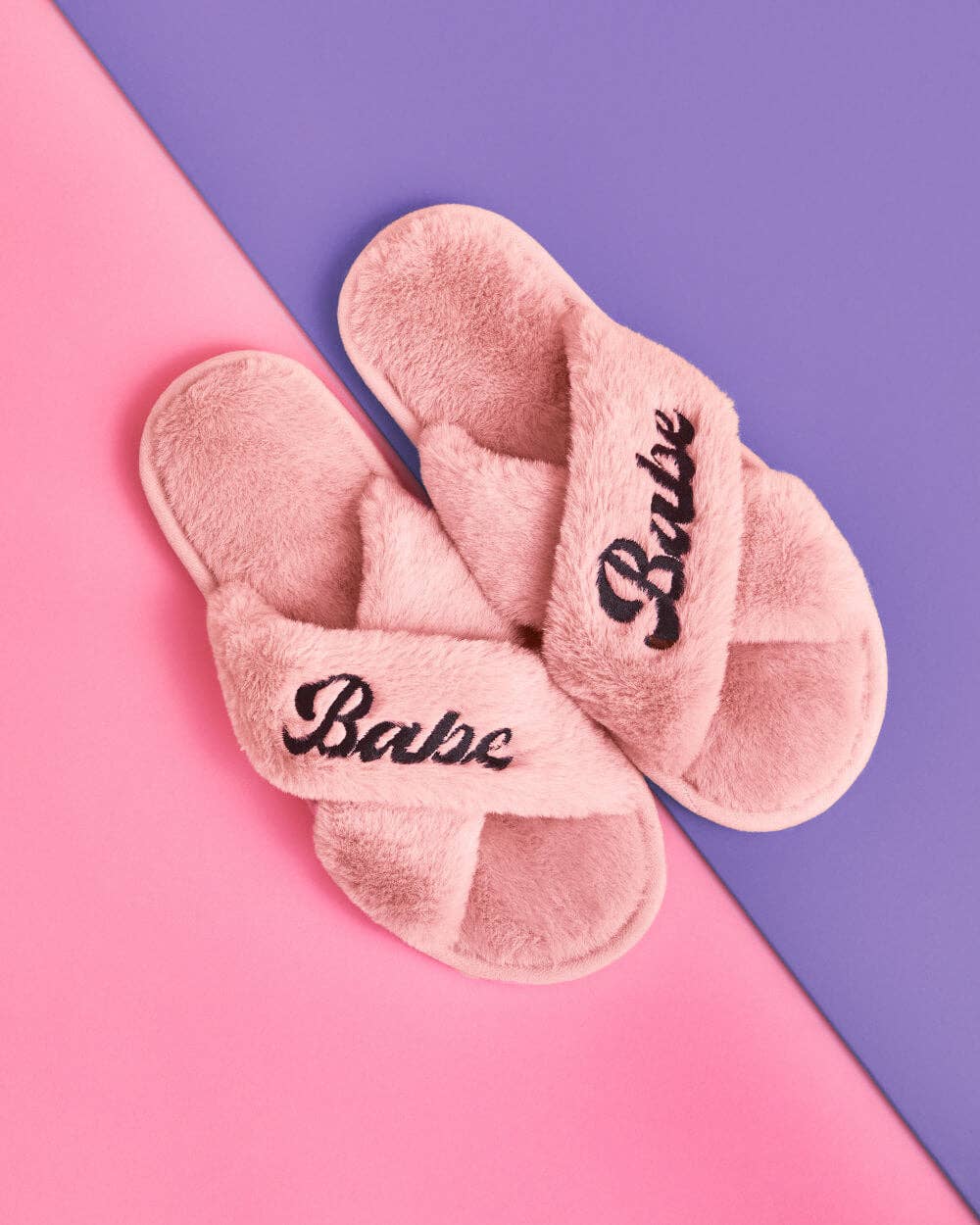Pink slippers with 'Babe' text on a pink and purple background