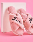 Pink slippers with 'Barbie' text on a pink background