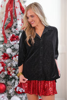 a plush velvet button-up top with subtle metallic threading, a relaxed flattering fit, three-quarter sleeves, and a soft drape for easy elegance in black