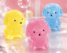a gel-filled puppy-shaped squishy with a translucent crystal-like texture, assorted colors, tiny face details, and a soft handheld design in blue, pink, and yellow