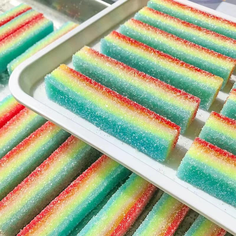 Colorful striped sour rainbow candy squishies on a white tray