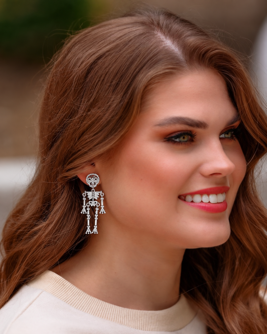 gold-plated post-back skeleton-shaped dangle earrings with rhinestone accents, skull stud tops, articulated bone design, matching barrel backs, and nickel/lead compliant construction in silver