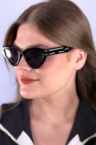 glossy black cat-eye sunglasses with dark lenses, silver and white raised accent on the temple, and brand name detail (on both the temple and the complimentary black pouch)
