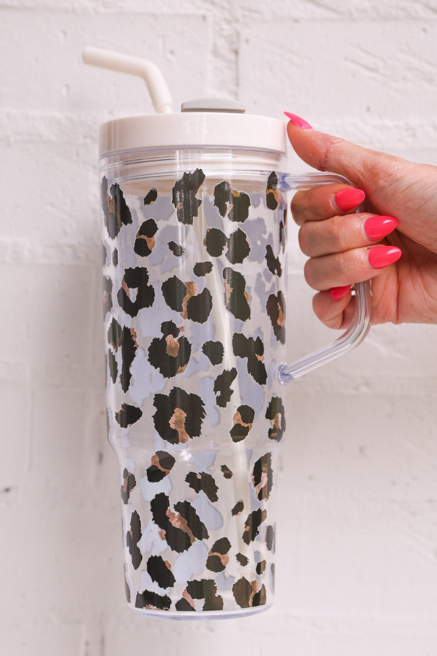 40-ounce black and brown animal print acrylic tumbler with a reusable straw (ivory), flexible mouthpiece (ivory), handle, screw-on lid (ivory with a grey rotate lid tab), and car cup holder compatible