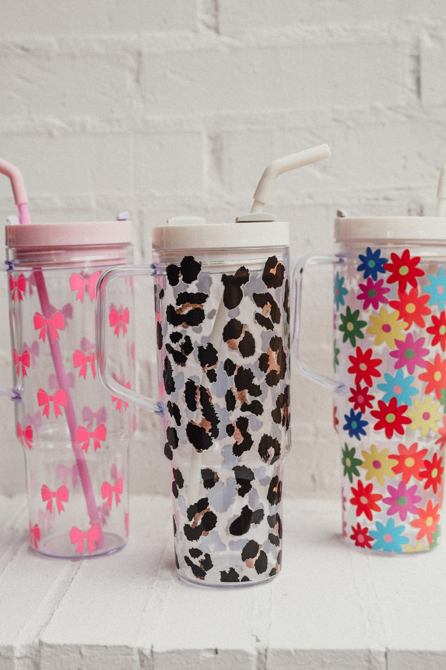 40-ounce pink bows, animal. print, and flowers pattern acrylic tumblers with a reusable clear straw, flexible mouthpiece, handle, screw-on lid, and car cup holder compatible