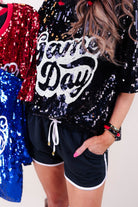 a full sequin design on a solid color with the words GAME DAY on the center front outlined in white sequins, a boxy fit, and a lined interior