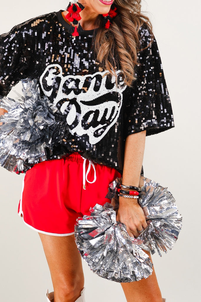 a full sequin design on a solid color with the words GAME DAY on the center front outlined in white sequins, a boxy fit, and a lined interior