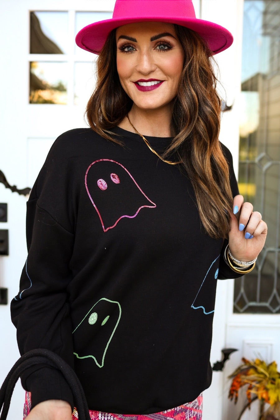 a black long-sleeve pullover crafted from soft fabric with a crew neckline, dropped shoulders, ribbed cuffs, banded hem, relaxed fit, classic sweatshirt silhouette, and colorful sequin ghost outline pattern across the front, back, and sleeve