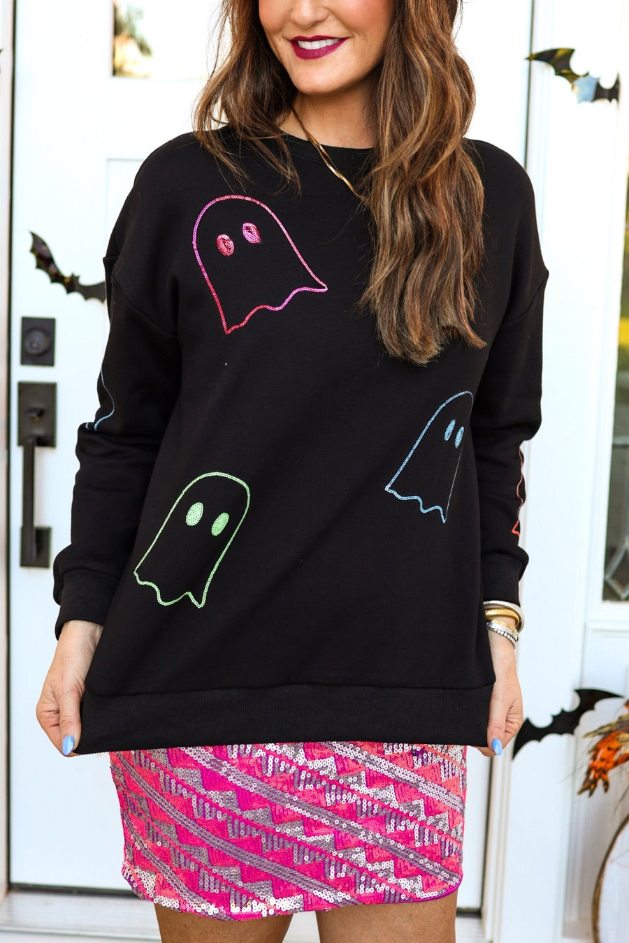 a black long-sleeve pullover crafted from soft fabric with a crew neckline, dropped shoulders, ribbed cuffs, banded hem, relaxed fit, classic sweatshirt silhouette, and colorful sequin ghost outline pattern across the front, back, and sleeve