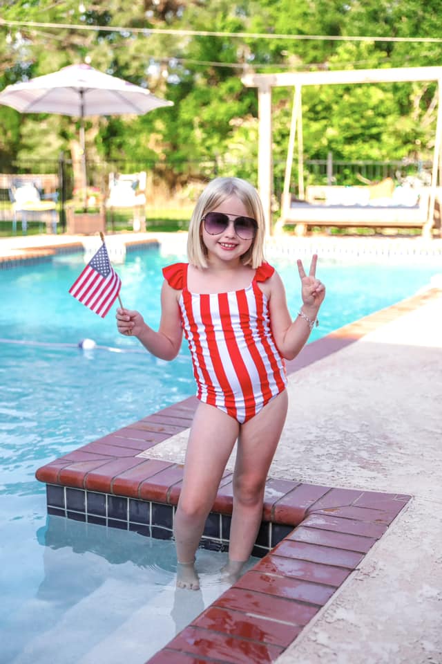 red and white vertical stripe one-piece swimsuit with ruffle sleeves and a criss-cross back