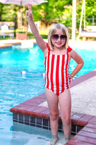 red and white vertical stripe one-piece swimsuit with ruffle sleeves and a criss-cross back