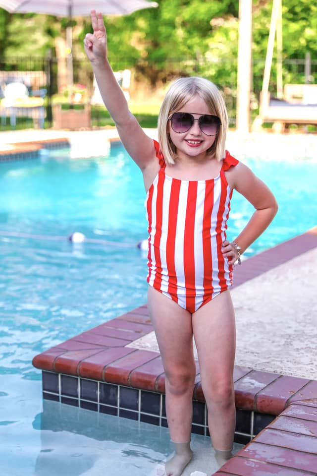 red and white vertical stripe one-piece swimsuit with ruffle sleeves and a criss-cross back