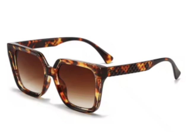 oversized square sunglasses in  tortoise with dark lenses, a raised geometric texture on the temples, and brand name detail (on both the temple and the complimentary black pouch)
