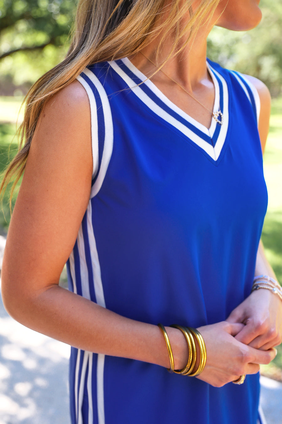 a blue two-piece sleeveless tunic and biker short set with varsity stripe trim, V-neckline, side slits, side pockets, soft stretch fabric, and pre-washed finish
