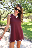 a maroon two-piece sleeveless tunic and biker short set with varsity stripe trim, V-neckline, side slits, side pockets, soft stretch fabric, and pre-washed finish