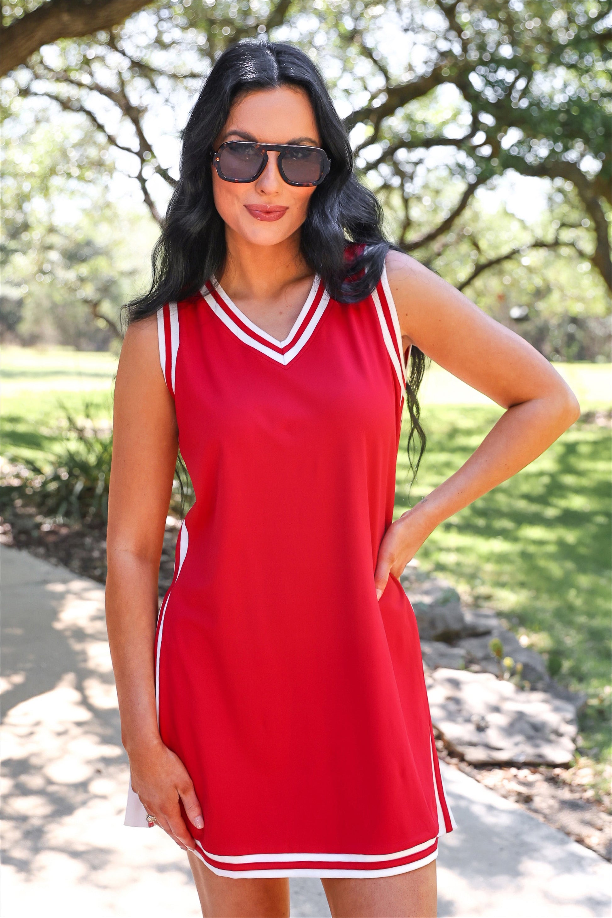 a red two-piece sleeveless tunic and biker short set with varsity stripe trim, V-neckline, side slits, side pockets, soft stretch fabric, and pre-washed finish