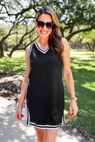 a black two-piece sleeveless tunic and biker short set with varsity stripe trim, V-neckline, side slits, side pockets, soft stretch fabric, and pre-washed finish