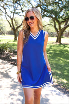 a blue two-piece sleeveless tunic and biker short set with varsity stripe trim, V-neckline, side slits, side pockets, soft stretch fabric, and pre-washed finish