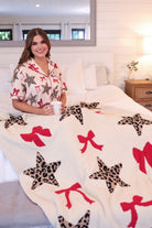 ultra-soft reversible throw on a leopard star and red bow pattern print fabric