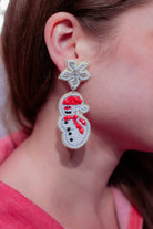 a star stud with a rhinestone center leading to mirror-image beaded snowmen, a comfort back earring with a plastic disc stopper in gold, and a white felt back