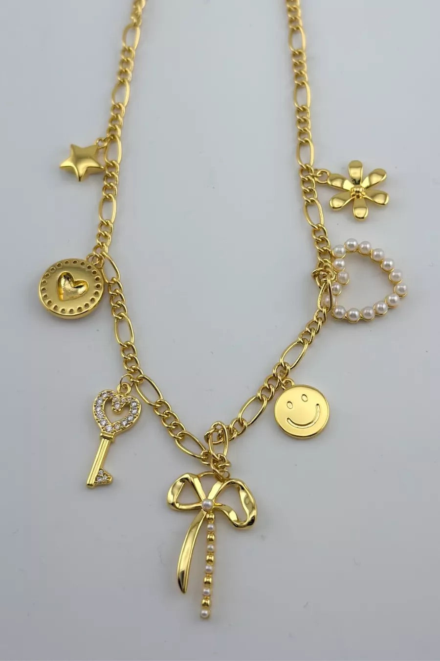 a gold-plated necklace with a stylish chain and seven charms adorned in pearls and rhinestones