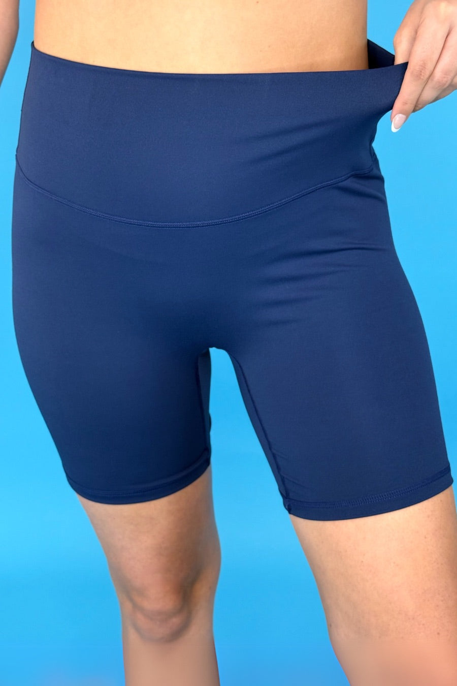 solid navy biker shorts made of buttery-soft, stretchy, and sleek lightweight material with a high elastic waistband and a flattering figure-hugging short silhouette