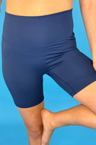 solid navy biker shorts made of buttery-soft, stretchy, and sleek lightweight material with a high elastic waistband and a flattering figure-hugging short silhouette