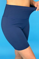 solid navy biker shorts made of buttery-soft, stretchy, and sleek lightweight material with a high elastic waistband and a flattering figure-hugging short silhouette