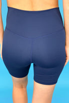 solid navy biker shorts made of buttery-soft, stretchy, and sleek lightweight material with a high elastic waistband and a flattering figure-hugging short silhouette