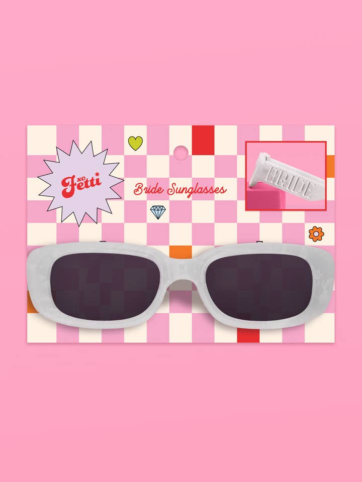 White sunglasses on a pink checkered background with 'Fetti' branding.