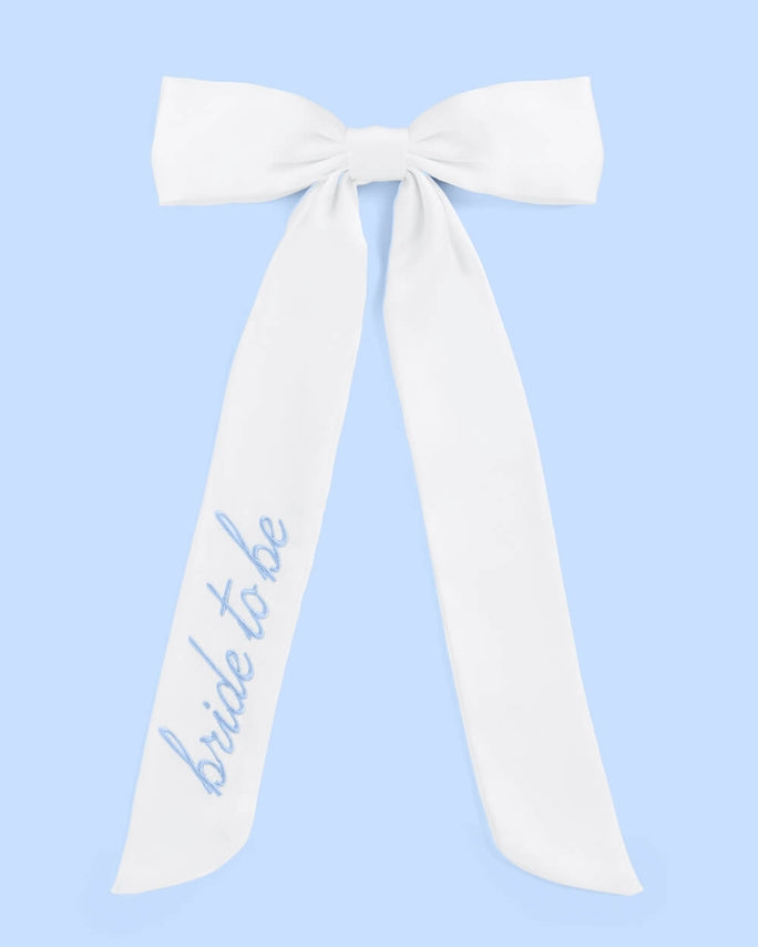 White sash with 'bride to be' text on a light blue background