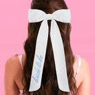 White hair bow with 'bride to be' text on a pink background