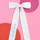 White sash with 'bride to be' text on a pink background