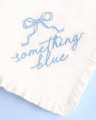 White fabric with blue embroidered text on a light blue background