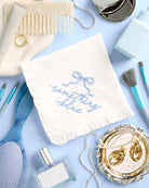 Collection of bridal accessories including a necklace, earrings, perfume, and a 'Something Blue' bag on a light blue background.