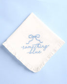 White handkerchief with 'something blue' embroidery on a light blue background