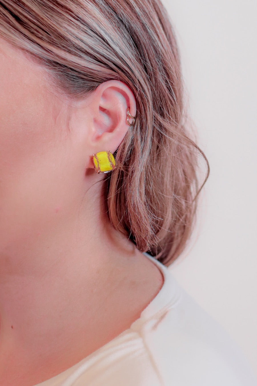 lightweight stud earrings with sporty prints with gold post-style earring backs and clear rubber stopper in yellow for softball