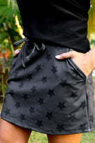 mid-rise relaxed fit everyday skort made of lightweight material with built-in black shorts, drawstring tie, an elastic band on the back, and side pockets, designed on a two-tone black star pattern print