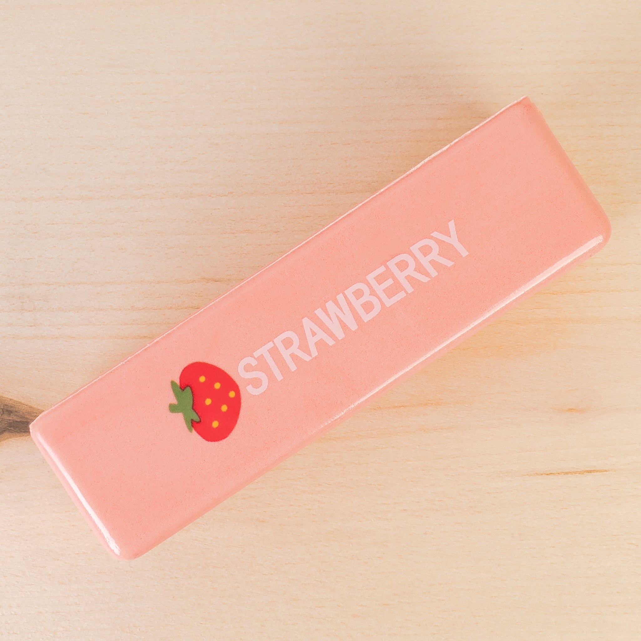 a 4oz strawberry butter-stick inspired foam fidget toy made from slow-rise polyurethane (PU) foam with a soft texture, pastel pink design, a tiny strawberry accent detail, playful printed lettering, and individual packaging
