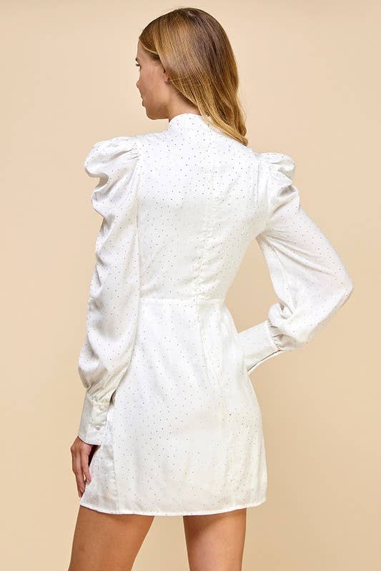 a white lined studded sheath dress with a high neckline accented with a decorative bow, puff shoulders, long cuffed sleeves, and a hidden rear zipper