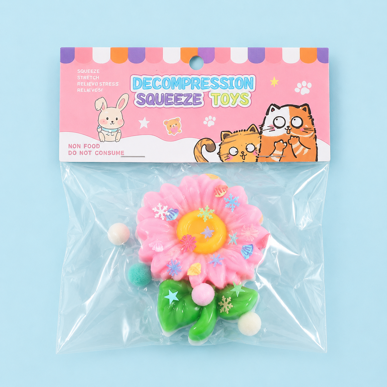 a pink flower-shaped decompression squishy toy with glossy petals, green leaves, mini decorative accents, and pastel pom poms