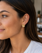 gold intricately detailed flower stud-post earrings with a center stone and gold comfort earring back