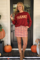 long-sleeve burgundy pullover with plaid 'THANKS' letters outlined in embroidery on a soft fabric