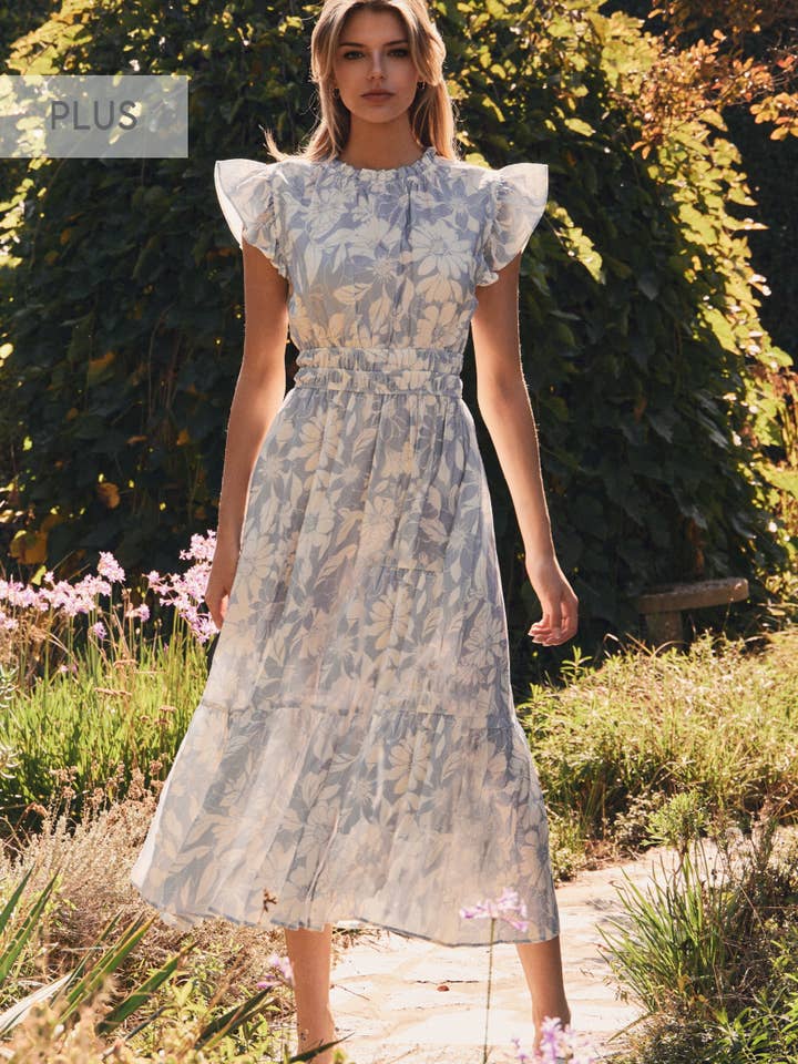 Woman wearing a floral dress standing in a garden setting