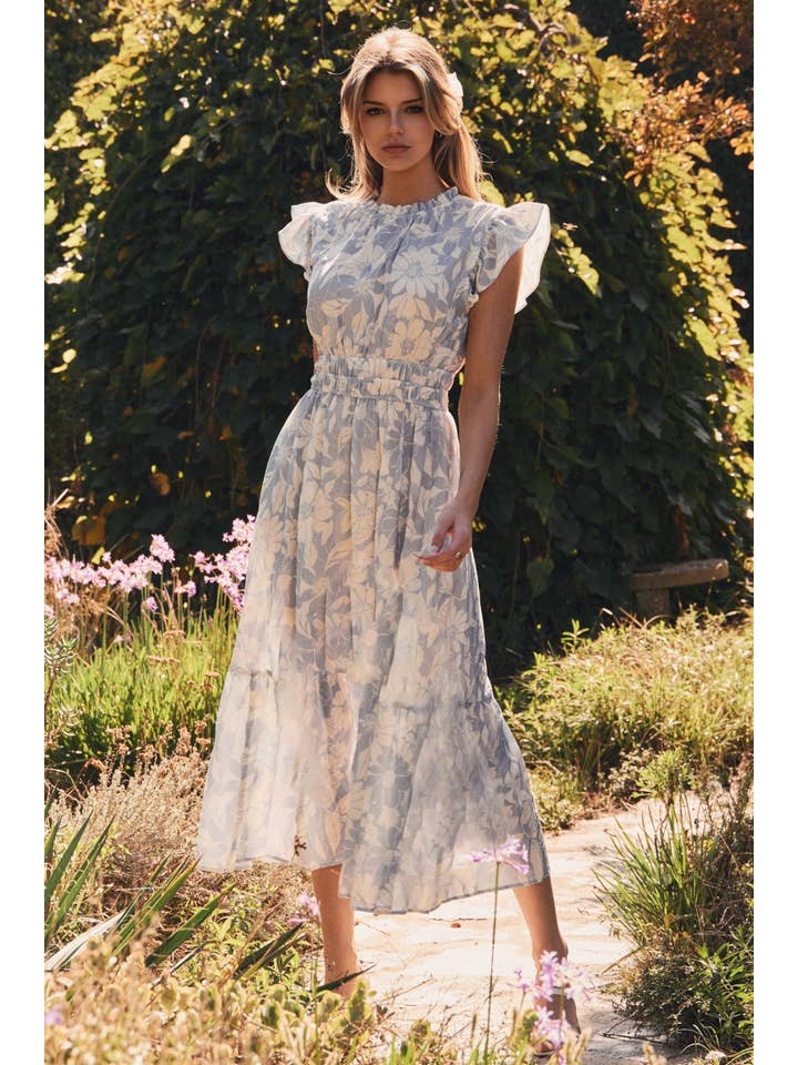 Woman in a floral dress standing in a garden setting