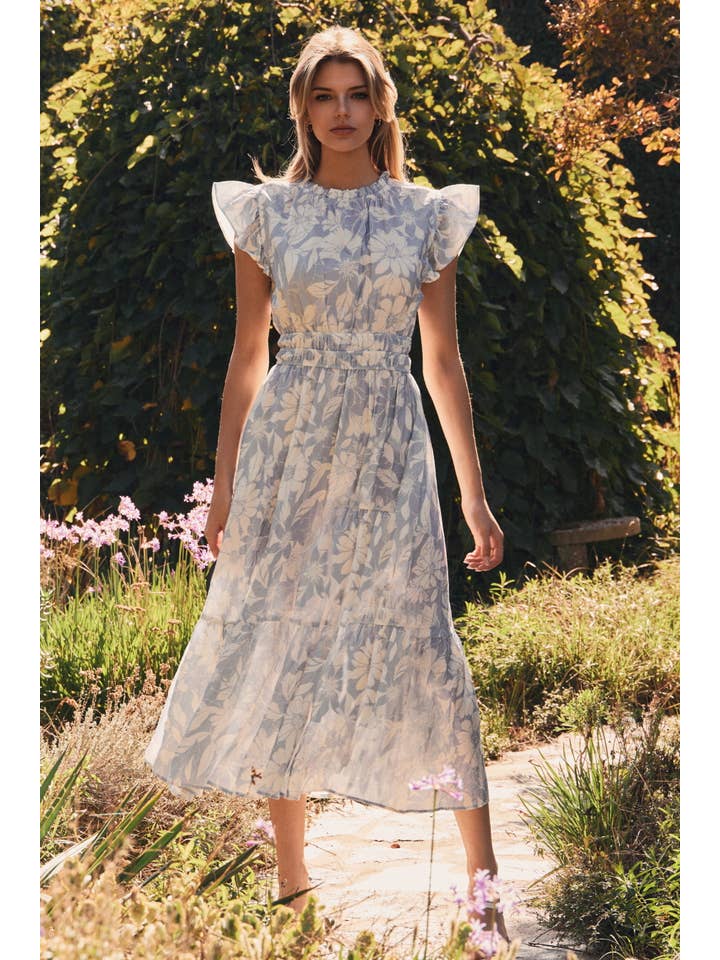 Woman in a floral dress standing in a garden setting