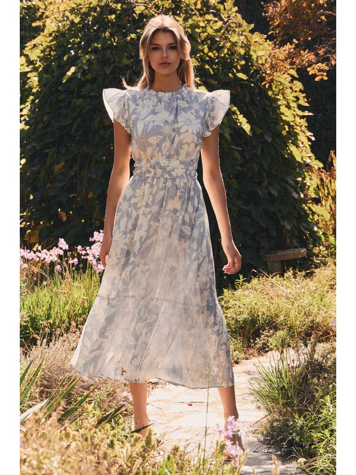 Woman in a floral dress standing in a garden