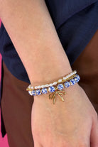 three-piece bracelet set with a charming mix of brass, sheer pearls, floral-patterned beads, and a dainty bow accent
